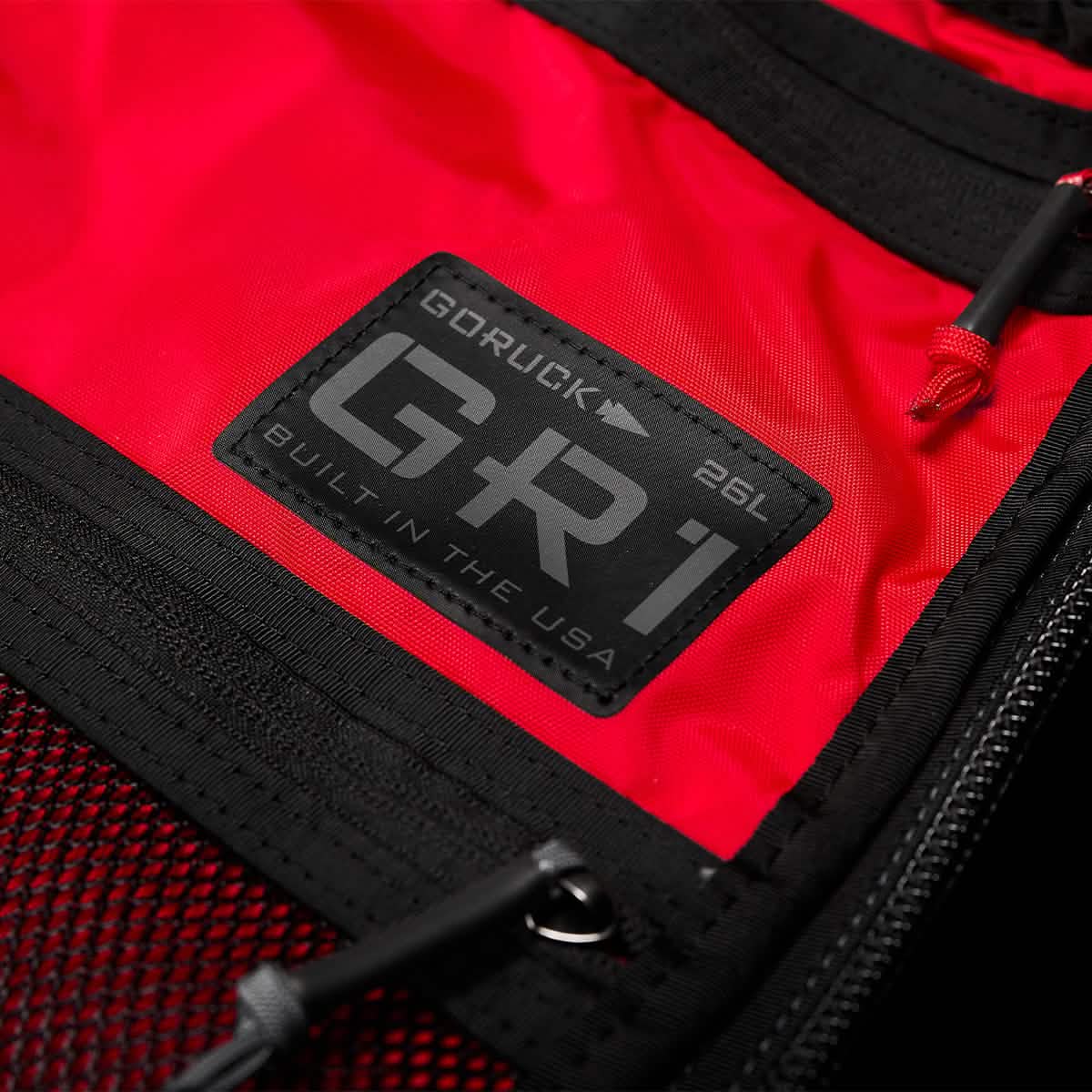Close-up of a red GORUCK GR1 USA - X-PAC rucksack showcasing a black label with 