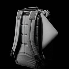 GORUCK rugged backpack with padded straps and a laptop partially inserted in the side zipper pocket