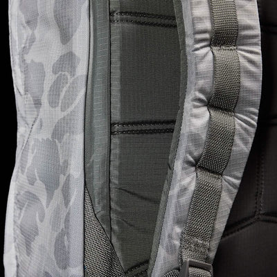 Close-up of the GORUCK GR1 USA - Ripstop ROBIC® backpack featuring a camouflage pattern. The image highlights its padded straps and detailed stitching, showcasing the texture and design of its ultra-lightweight fabric. The colors predominantly include shades of gray and green.