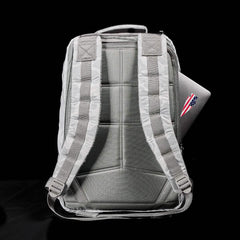 Back view of gray GORUCK backpack with padded straps and a partially visible laptop in side compartment