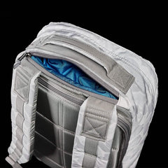 Close-up of white GORUCK rucksack straps and padded back panel with blue interior lining visible