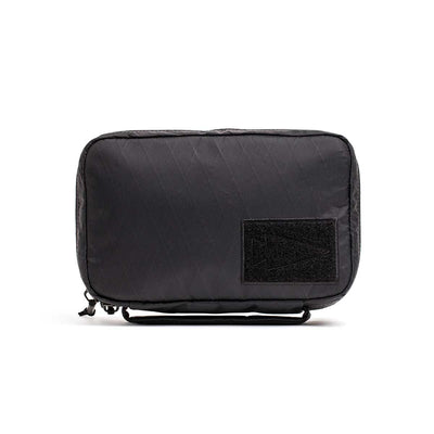 The GR1 Field Pocket - X-PAC is a rectangular black electronics organizer made from waterproof X-PAC fabric, with AquaGuard zippers and a front patch, displayed on a white background.