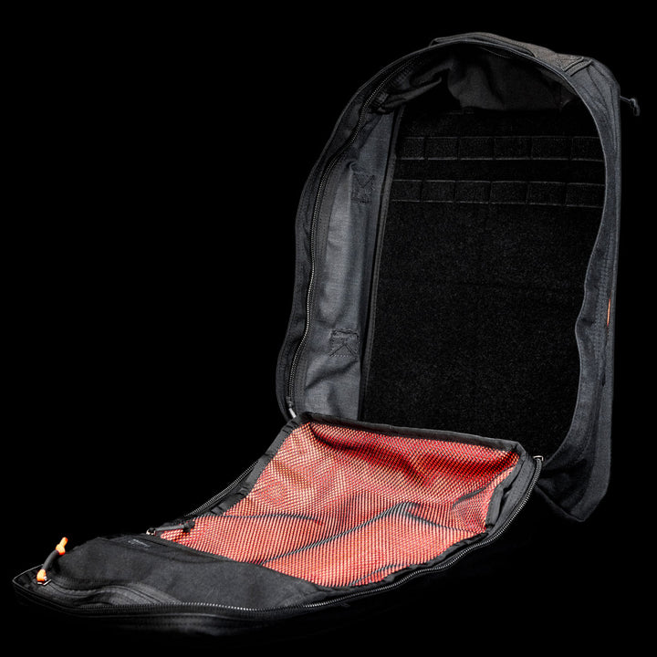 Open black GR1 Shooter 26L - Built by Scars backpack, made from Special Forces Grade CORDURA®, with a red mesh inner pocket, shown against a black background.