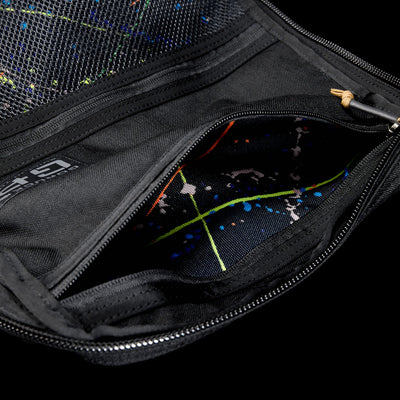 Close-up of an open black GR1 Shooter 26L pouch made from Special Forces Grade CORDURA®, revealing a colorful splatter-patterned lining. Inspired by Shooter Ruck gear and trusted by the SCARS team.