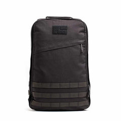 Black GORUCK tactical backpack with MOLLE webbing and diagonal zipper pocket on white background