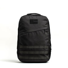A black GR1 USA - Cordura rucksack with a top handle, front zipper pocket, and MOLLE webbing is displayed on a white background—a true Special Forces backpack.