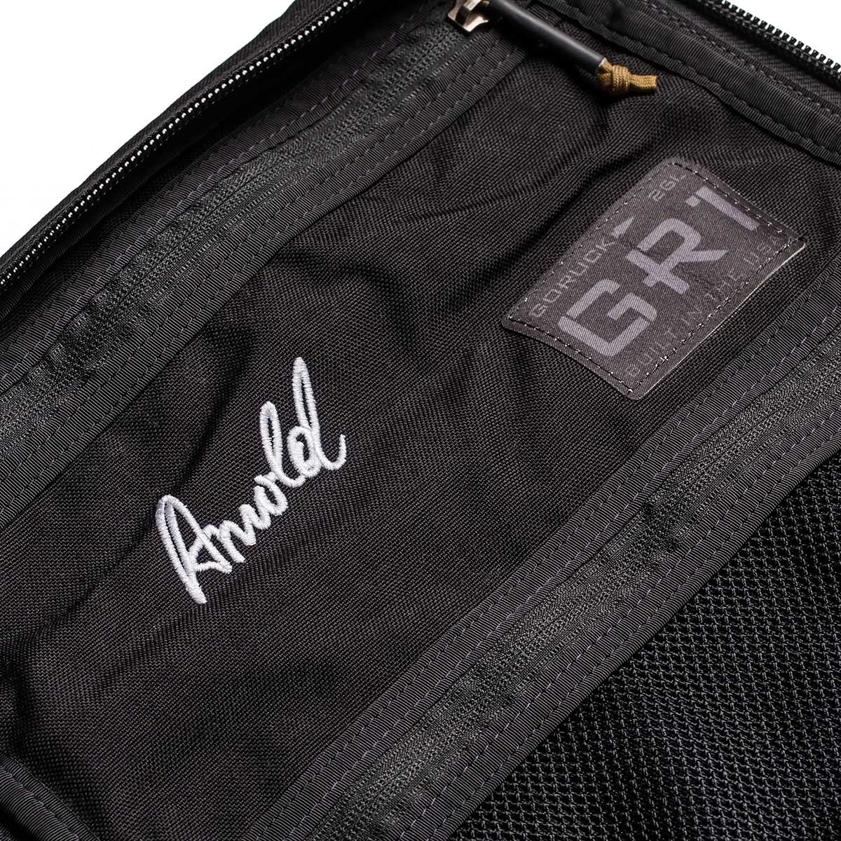 Close-up of the 26L GR1 USA - GORUCK x Arnold's Pump Club backpack with a stitched "Arnold" name and GORUCK patch inside, highlighting this limited-edition, built in USA rucksack.