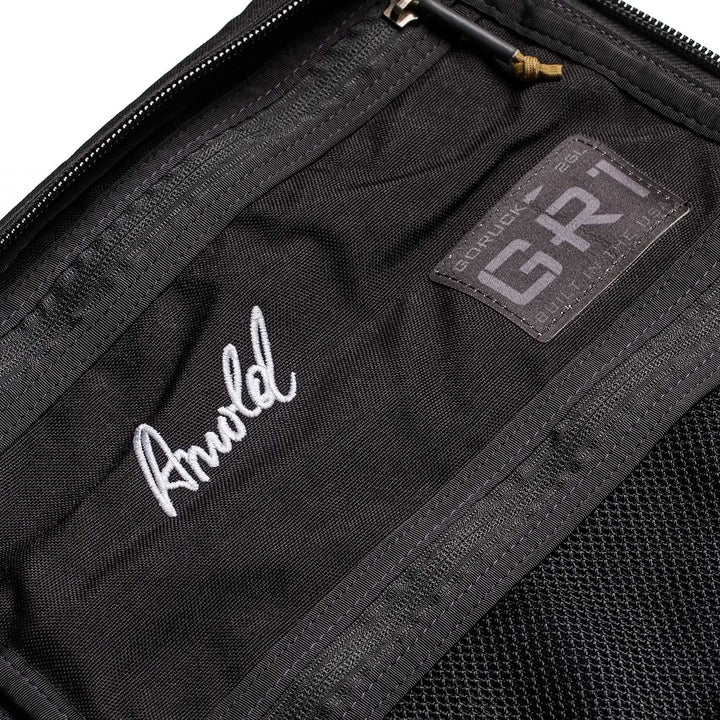 Close-up of the 26L GR1 USA - GORUCK x Arnold's Pump Club backpack with a stitched "Arnold" name and GORUCK patch inside, highlighting this limited-edition, built in USA rucksack.