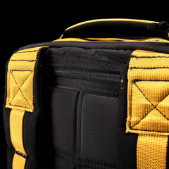 Close-up of the durable GR1 USA - Cordura rucksack by GORUCK, featuring yellow straps and stitching against a black background, designed to meet Special Forces ruggedness.