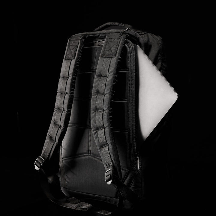 The GR1 USA - Ripstop ROBIC® backpack, crafted from ultra-lightweight 420D Robic® Ripstop Nylon, features padded straps and holds a partially visible laptop against a dark background.