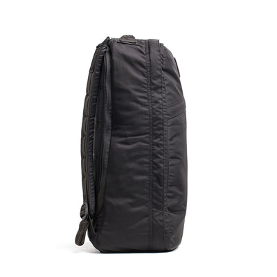 Side view of a GR1 USA - Ripstop ROBIC® backpack standing upright, featuring its sleek profile crafted from water-resistant ripstop nylon and textured fabric.