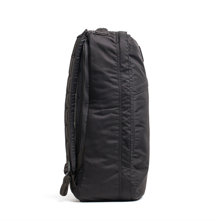 Side view of a GR1 USA - Ripstop ROBIC® backpack standing upright, featuring its sleek profile crafted from water-resistant ripstop nylon and textured fabric.