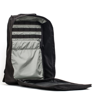 The GR1 USA - Ripstop ROBIC® black backpack, made from ultra lightweight 420D Robic Ripstop Nylon, reveals internal pockets and straps for organization when the front compartment is unzipped.