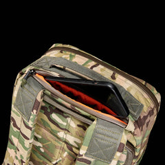 GORUCK multicam rucksack pocket with orange interior and black smartphone inside on black background