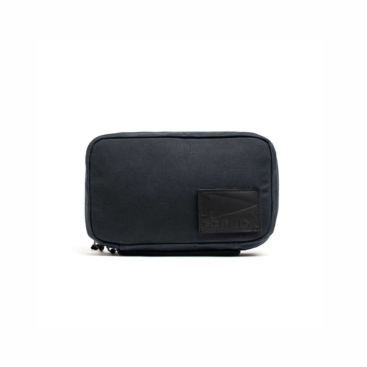 A compact black GR1 Field Pocket - Waxed Canvas with a stitched leather patch on the lower right corner, shown against a white background.