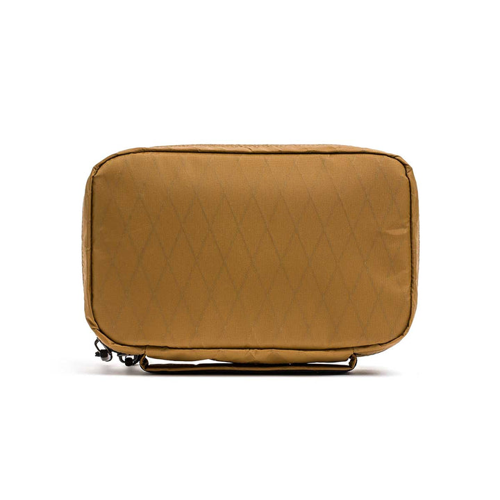 The GR1 Field Pocket - X-PAC is a rectangular tan pouch with a diamond pattern, made from waterproof X-PAC fabric and featuring a top zipper.