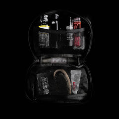 The GR1 Field Pocket, shown open on a dark background, is a black dopp kit with mesh pockets—perfect for grooming essentials, hygiene items, or organizing electronics.