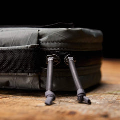 Close-up of durable GORUCK rucking gear zipper pulls on rugged fabric against a wooden surface