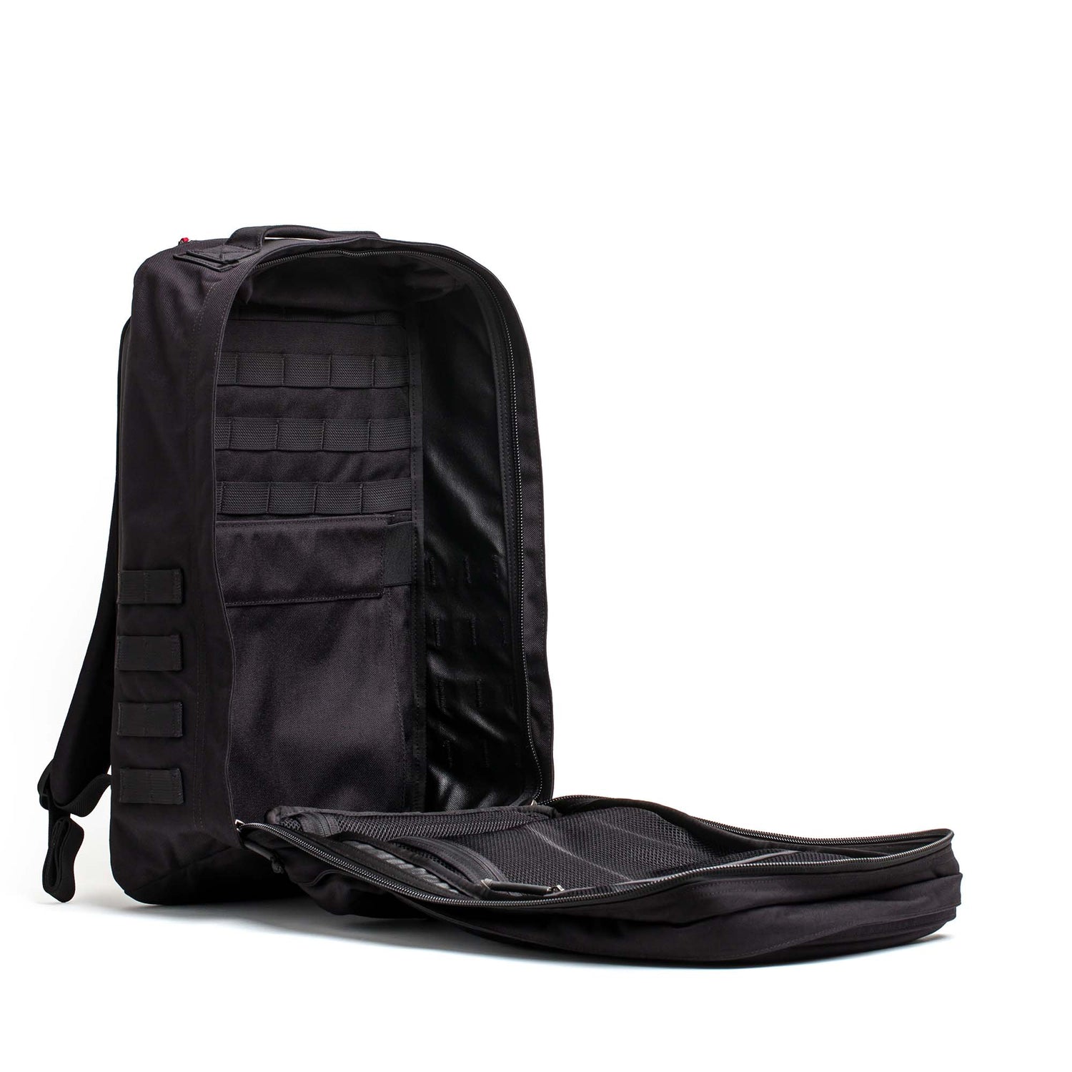 A black GR2 - Cordura ruck backpack with its main compartment unzipped and open, revealing organized interior pockets and slots.