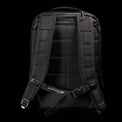Displayed against a dark background is the GR2 - Ripstop ROBIC® rucksack in black, complete with padded shoulder straps and a chest strap. The back panel includes quilted padding for added comfort, while the GORUCK brand name is visible on the chest strap. This water-resistant travel bag combines style and practicality, making it an ideal companion for any journey.