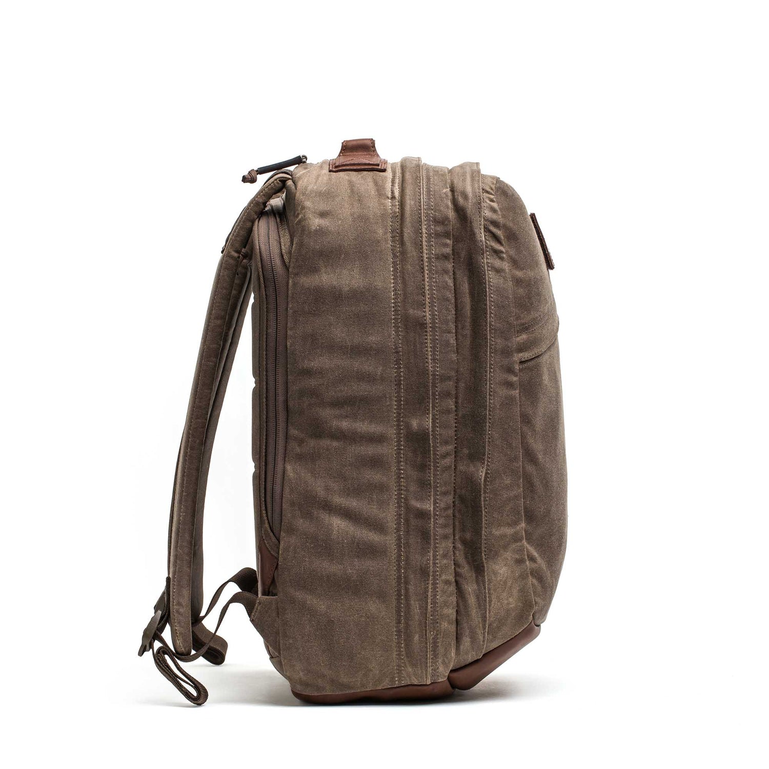 Side view of the GR2 - Heritage Waxed Canvas backpack in brown, featuring adjustable straps; ideal as a travel ruck. Shown against a white background.