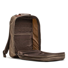 The GR2 - Heritage Waxed Canvas stands upright with its main compartment open, showing multiple interior pockets—ideal for travel or daily use.
