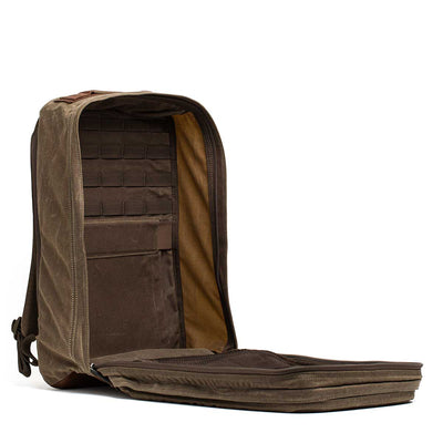 The GR2 - Heritage Waxed Canvas is a brown backpack with a main compartment that fully unzips to reveal internal pockets and organizers.