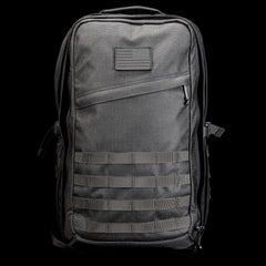 Black GORUCK tactical rucksack with MOLLE webbing and subdued flag patch on front