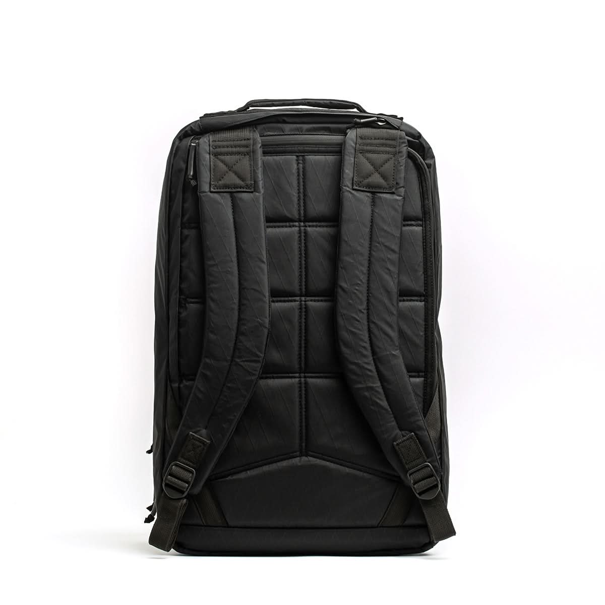 The GR2 X-PAC backpack is shown from the back, featuring padded shoulder straps, a quilted back panel, and waterproof AquaGuard zippers.