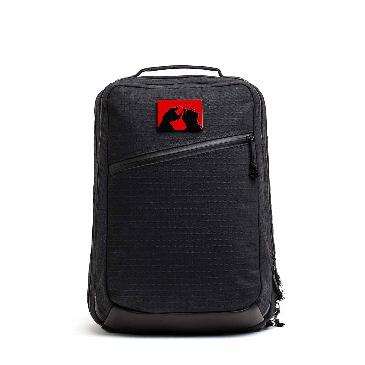 The GR2 x Carryology - GRXC2 Samurai 2.0 is a black backpack with a red patch showing two black cat silhouettes, made from premium JPXDP denim in a special Japan Blue collaboration.