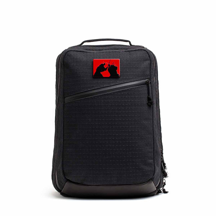 The GR2 x Carryology - GRXC2 Samurai 2.0 is a black backpack with a red patch showing two black cat silhouettes, made from premium JPXDP denim in a special Japan Blue collaboration.