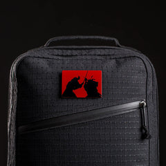 Black GORUCK backpack with diagonal zipper and red Samurai 2.0 patch featuring sword duel silhouettes