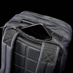 A top view of the GR2 - Waxed Canvas by GORUCK showcases its black exterior, padded straps, and an open main compartment with a smartphone partially tucked inside. The back features a textured, quilted design that exudes classic elegance.
