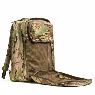 The GR2 X-PAC is a camouflage-patterned tactical backpack with AquaGuard zippers, shown with its front pocket open and mesh lining visible.