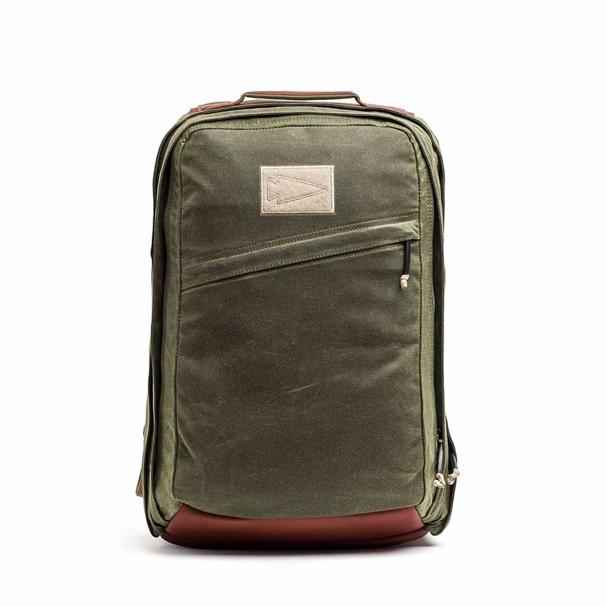 Introducing the GR2 - Waxed Canvas by GORUCK: a green backpack designed in a classic, rectangular shape reminiscent of a Heritage Retro Rucksack. It features Red Wing Leather accents on the top and bottom and includes a front zippered pocket for added utility. With a loop handle, this rugged and functional backpack is ideal for modern adventurers.