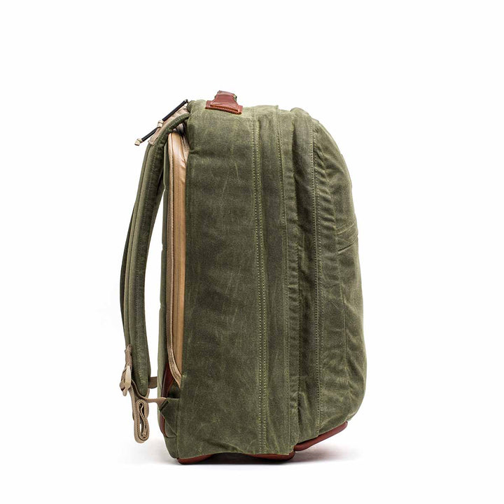 Side view of the GR2 - Waxed Canvas backpack in green with brown accents, zippers, and adjustable shoulder straps—crafted from durable duck canvas for dependable travel use.