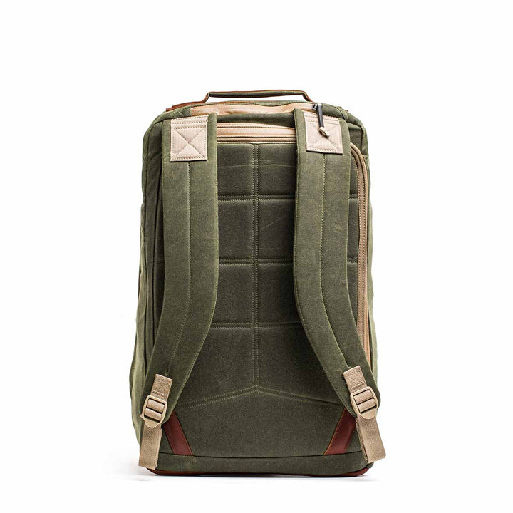 The GR2 - Waxed Canvas is an olive green backpack with tan straps, made from durable waxed duck canvas, shown from the back with padded shoulder straps and a top handle.