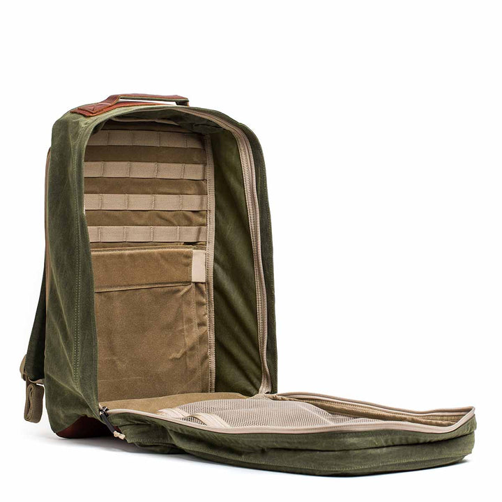 The GR2 - Waxed Canvas in olive green features a front flap open to reveal multiple interior pockets and compartments, all crafted from durable waxed duck canvas.