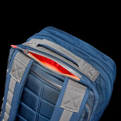 A close-up of the GR2 - Cordura ruck shows off its rugged design, with a partially open zipper revealing a vibrant orange interior against a stark black background.