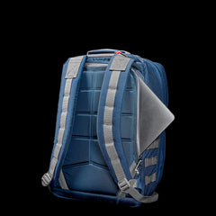 The GR2 - Cordura, a blue ruck with gray straps and a laptop partially tucked inside, stands against a black background, evoking the look of Special Forces gear.