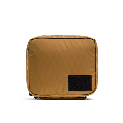 The GR2 Field Pocket - X-PAC is a square tan electronics organizer pouch with a black front patch, made from waterproof fabric, shown on a white background.