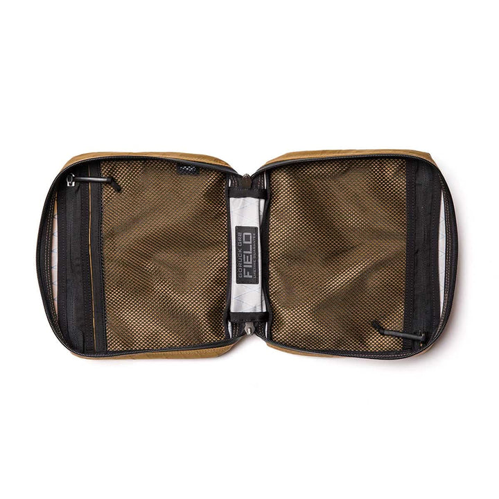 The GR2 Field Pocket - X-PAC is a brown, waterproof zippered pouch featuring AquaGuard zippers, two mesh pockets inside, and fits a Field Notes notebook when opened flat.