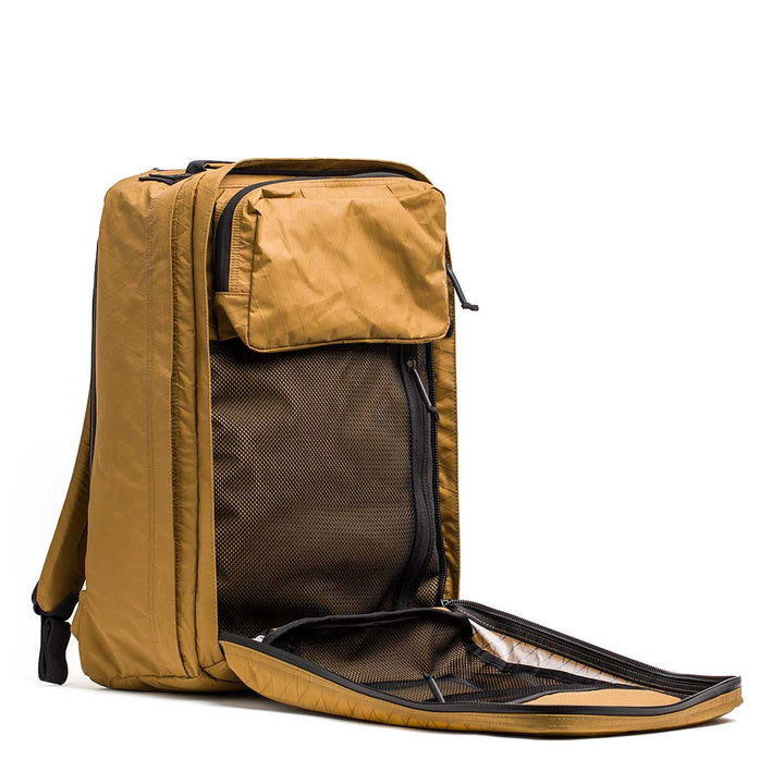The GR2 X-PAC is a brown travel backpack with a main compartment and front pocket open to reveal interior mesh organizers. It features AquaGuard zippers and a waterproof design to keep your gear safe in any weather.
