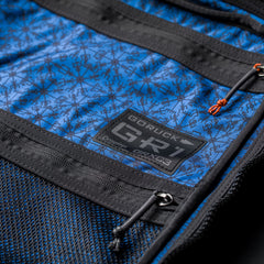 Close-up of the GR1 USA x Carryology - Berserker Viking backpack in blue and black, featuring a logo patch and zipper details, inspired by Viking warriors.