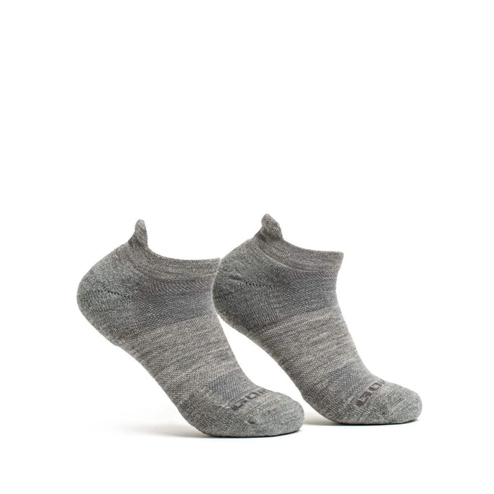 The Merino Challenge Socks - Ankle by GORUCK are showcased against a simple white backdrop. The gray wool socks stand upright, highlighting their subtle texture with a slightly darker heel and toe area, designed to excel in comfort.