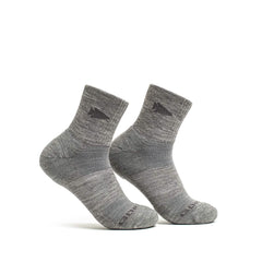 A pair of GORUCK's Merino Challenge Socks - Trail Cuff in gray, crafted from Merino wool, showcases a subtle dark pattern around the heel and toe. These socks, made in the USA, are arranged standing next to each other against a plain white background.