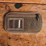 GORUCK coyote brown ID card organizer on rustic wooden table, rugged rucking gear accessory