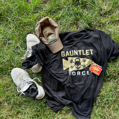 A black “Gauntlet Force” shirt, tan cap, white sneakers with Merino Challenge Socks - Ankle (No-Show), and a patch on green grass.