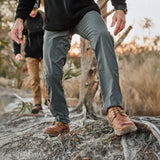 Two people hiking outdoors in rugged GORUCK gear and boots on a forest trail