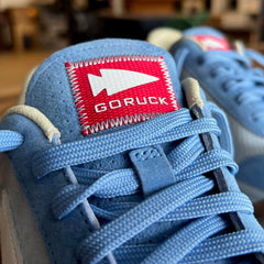 Close-up of the Mackall 45 Americana, a blue sneaker featuring a red “GORUCK” label with a white arrow logo on the tongue.